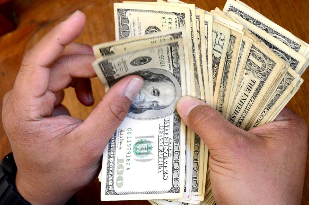 Manos contando billetes de dólares